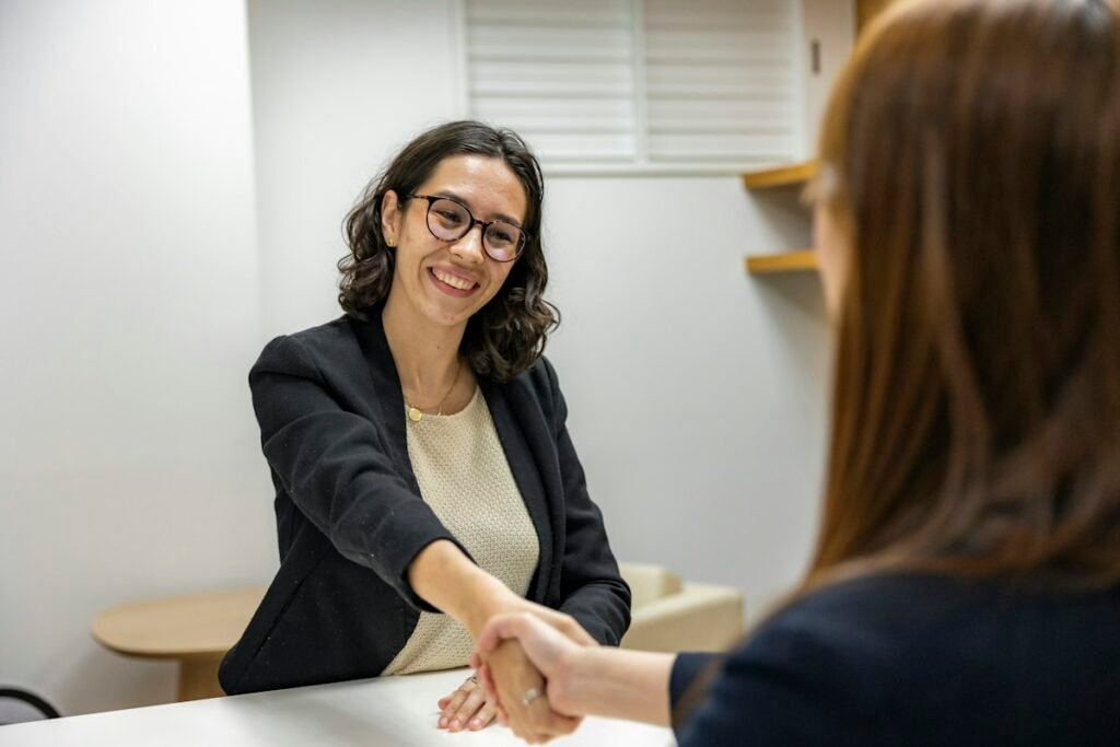 Smiling marketing consultant shaking hands with a small business client